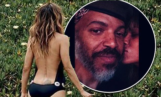 Halle Berry, 54, shows off her age-defying physique in a backless black swimsuit
