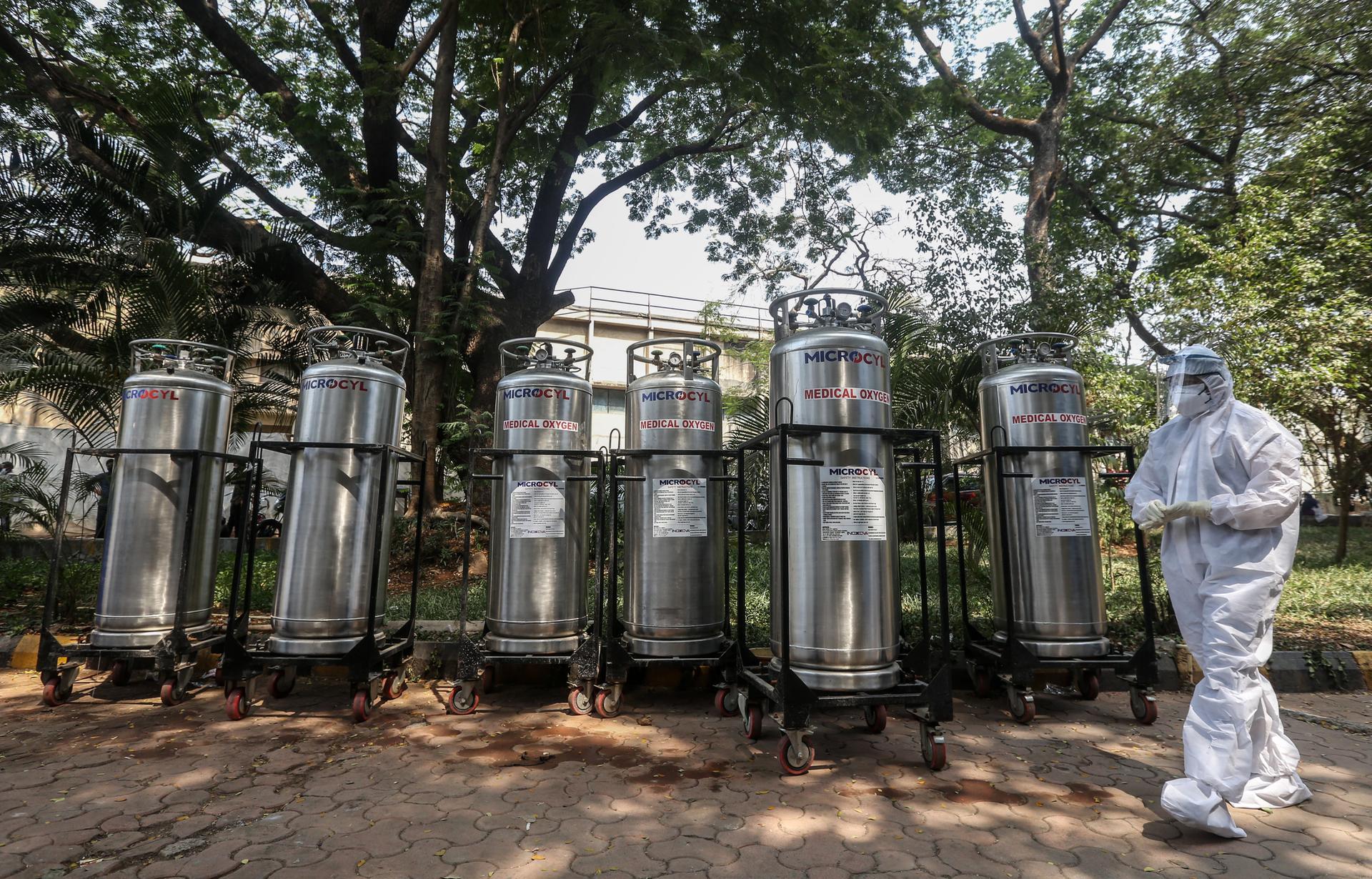 An Indian worker stands near oxygen cylinders at a jumbo Covid-19 centre in Mumbai. EPA