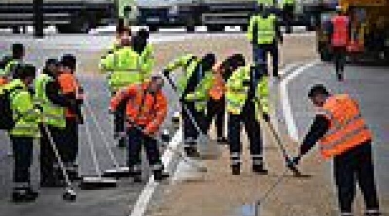 Royal fans left baffled as workers sweep sand onto the roads in central London for the coronation 